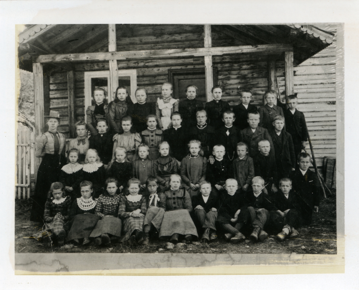 Elever og lærer utenfor Bøvarstogo skule, Etnedal, i 1905. Se vedlegget for navn på personene.
Bildet er trykket i avisa "Valdres" 04.06.1982