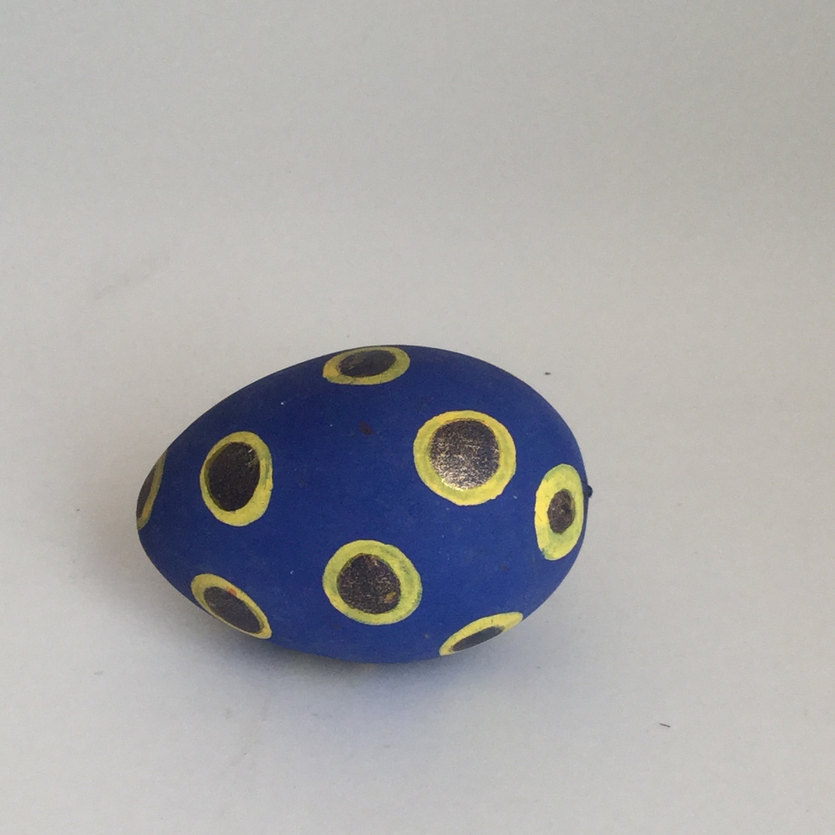 Prydnaden föreställer ett ägg.Ägget är svarvat i trä och är målat med prickar i gult och guld på blå botten.Höjd 70 mm, bredd 43 mm.