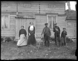 Gruppebilde foran hus i Komagvær. I slåttonna. Slottefolk. S