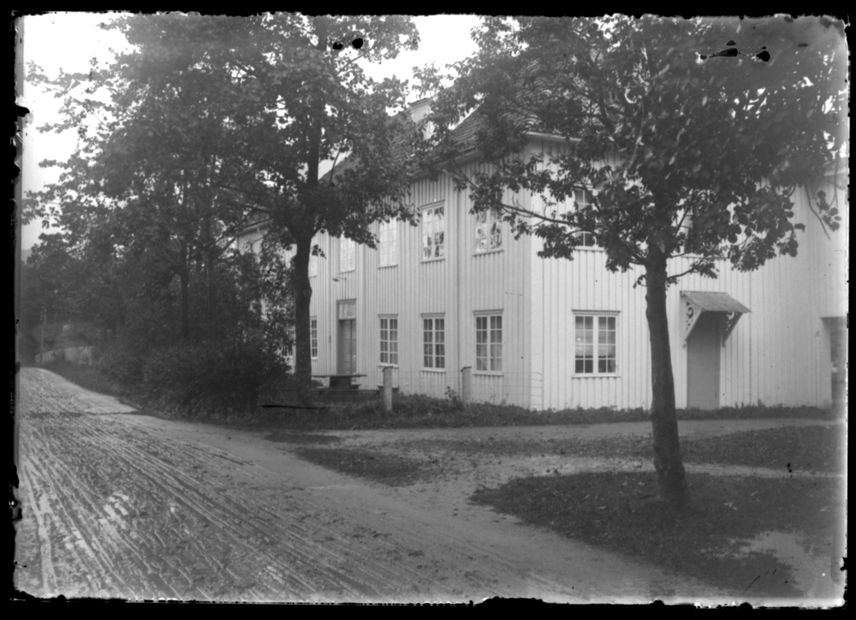 Fra stevne i Kristiansund. Et hus omgitt av høye trær.