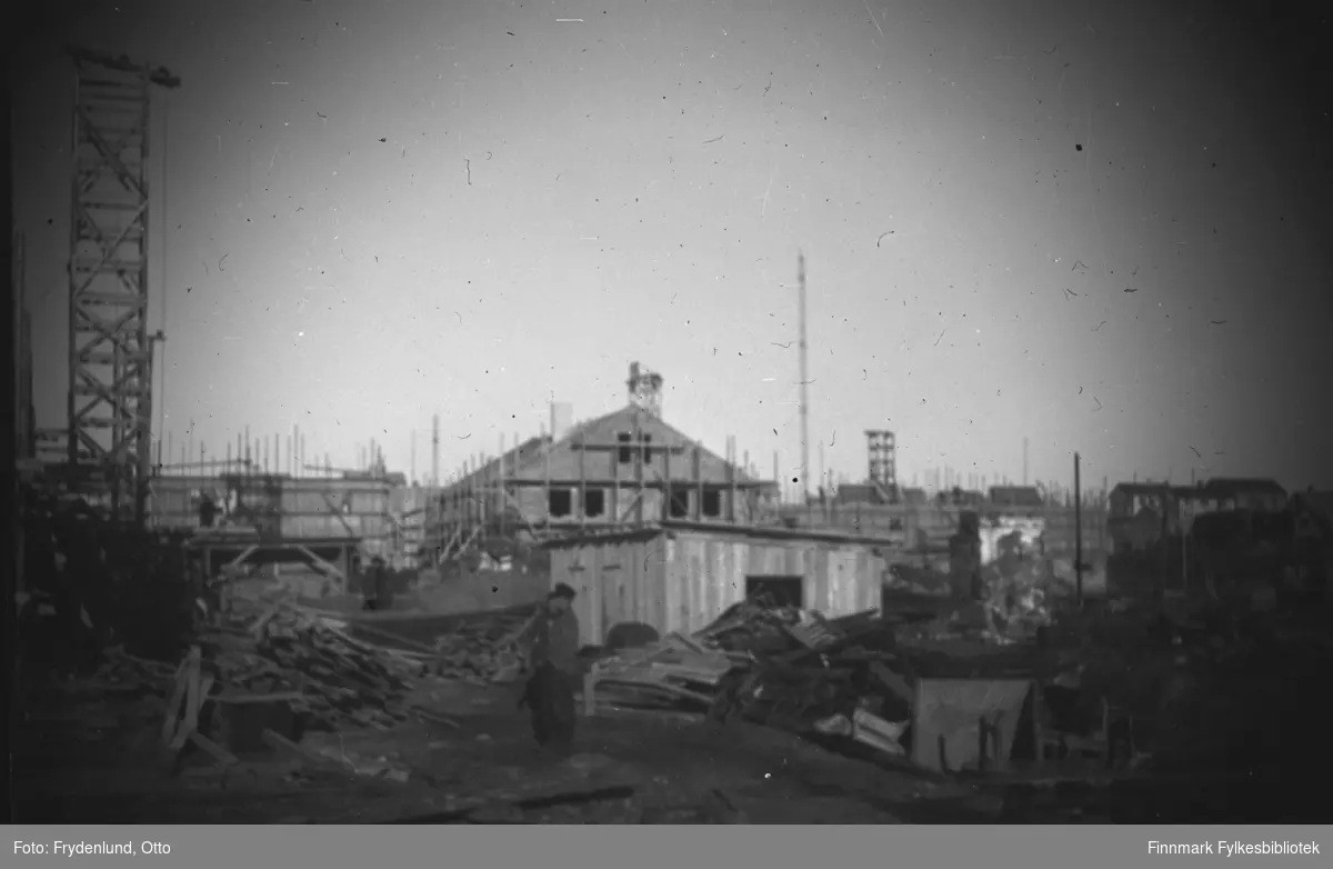 Bygninger rundt torget i Vadsø under bygging i 1947. Vi ser forskalinger, stillaser og heisekraner