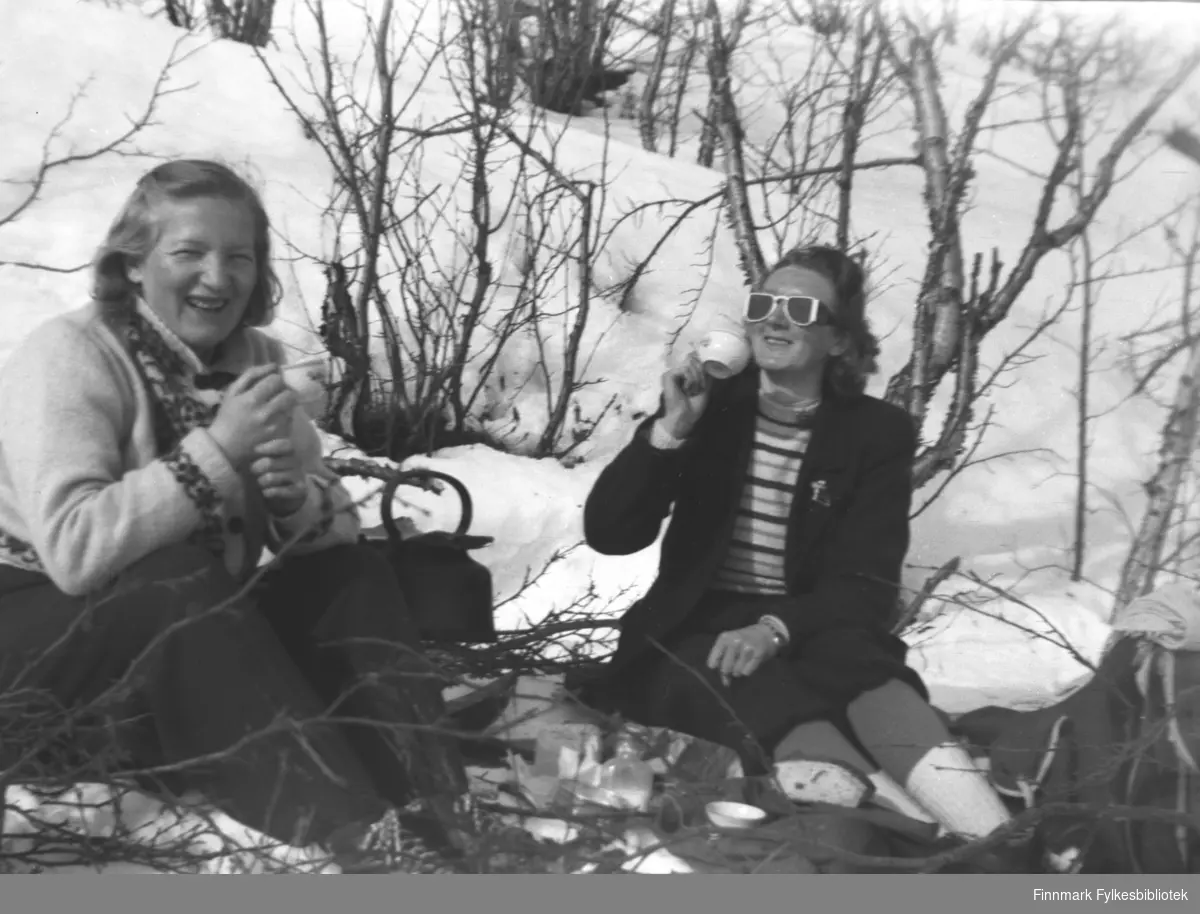 Kafferast med bål ute i snøen. Sola varmer nok godt, kvinnene er ikke altfor tungt kledde. Fra venstre Gudrun Olsen Lie og Marine Smuk