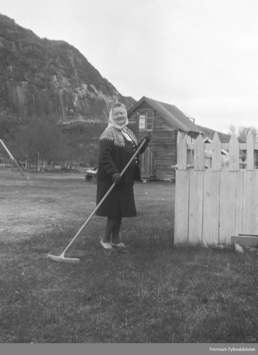 Hanna Kvandal, Kathinkas søster, med rive på gården Mikkelsnes. I bakgrunnen ser vi melkebua på gården