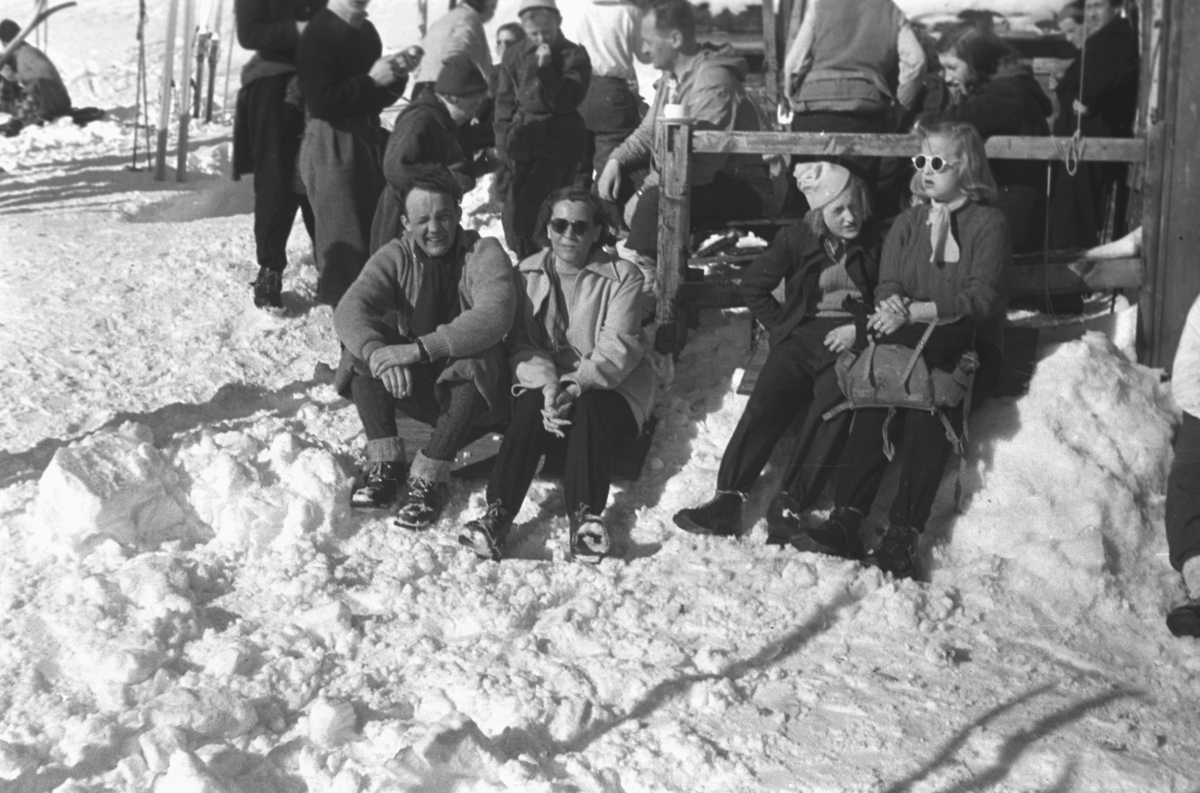 En værmessig flott vinterdag i Vadsø med endel folk ute på tur. Nederst til venstre på bildet sitter Anders Aune og ved siden av han sitter Frida Hauge. Resten er ukjente.