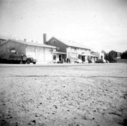 To store bygninger i enden av et grusdekt område. Bygget til