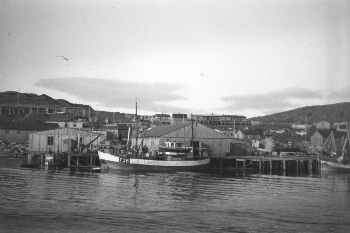 Bilde viser havneområde i Mehamn. Bildet er tatt i mai 1946. En fiskeskøyte ligger ved kai.