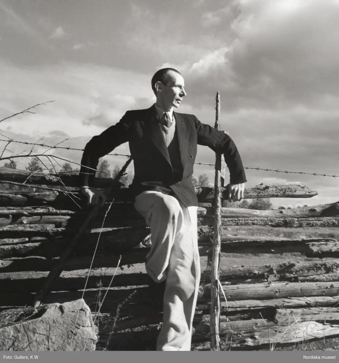 Porträtt av poeten Nils Ferlin (1898–1961) stående vid en gärdesgård.