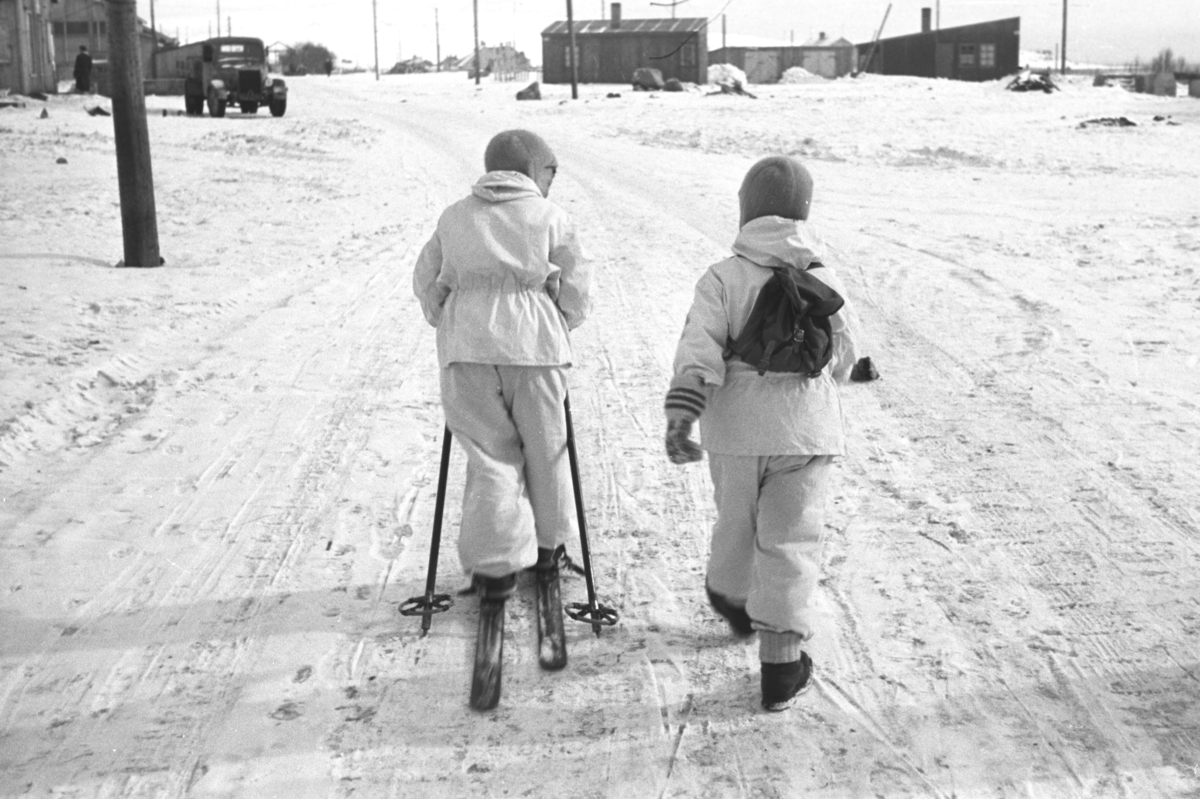 To gutter er ute og går en vinterdag. Øystein Hauge til venstre på bildet og Rolf Hauge med ryggsekk på ryggen.
