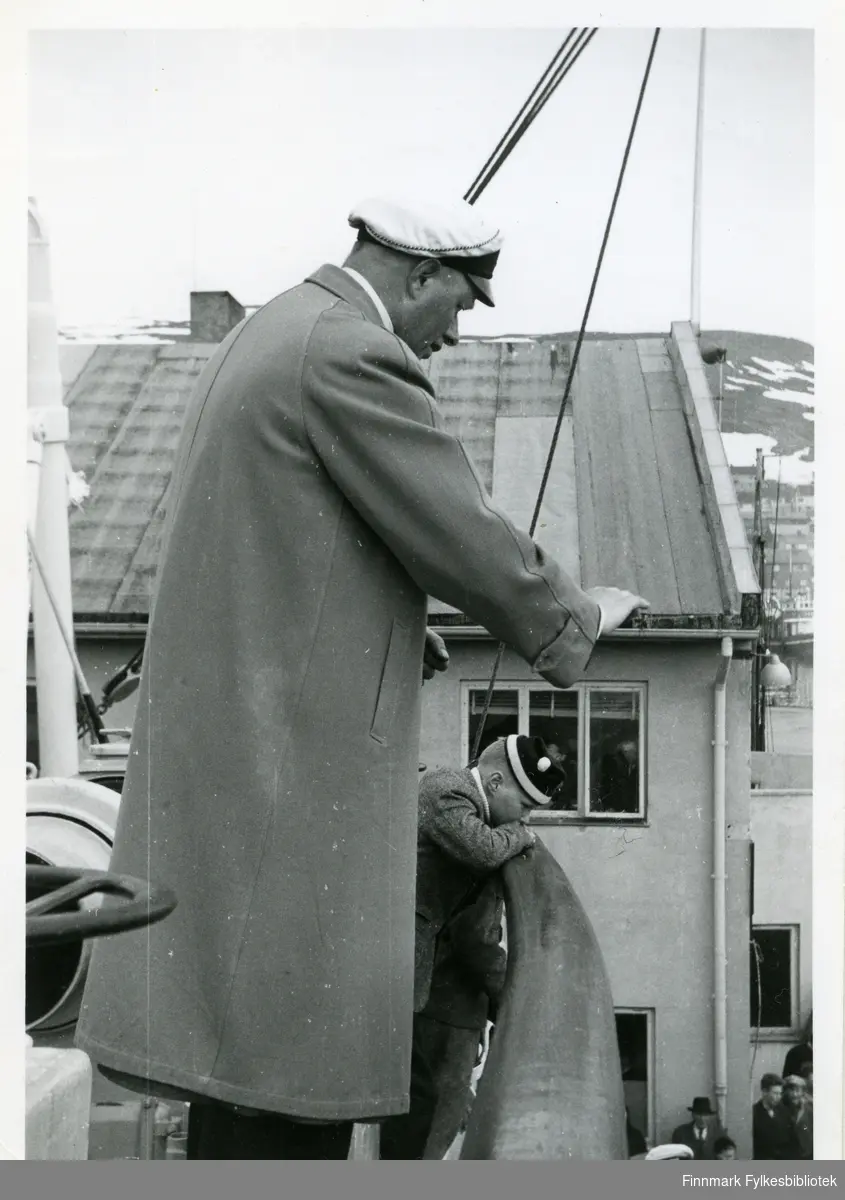 Bildet viser Bugge fra Bjørnvatnet under korstevnet i Honningsvåg pinsen 1956. Han dirigerer trolig et kor. På seg har han en lang jakke og hatt. Bak han kan man se en liten gutt lene seg mot relingen. Gutten har på seg en lue. Bak dem kan man se et hus med vindu og pipe. Enda lenger bak er fjell syndlige.
