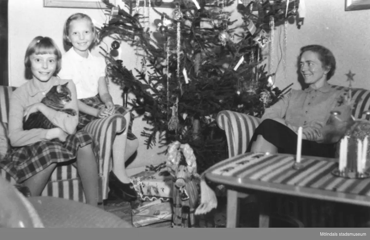 Systrarna Eva med katten Tussi i knäet och Karin samt modern Rosa Pettersson, juletid 1955 på Gamlehagsvägen 17 i Kållered.