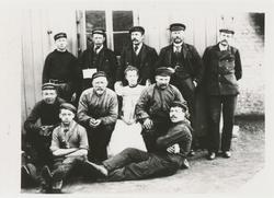 Gruppebilde av et båtmannskap. Ti menn og ei kvinne.