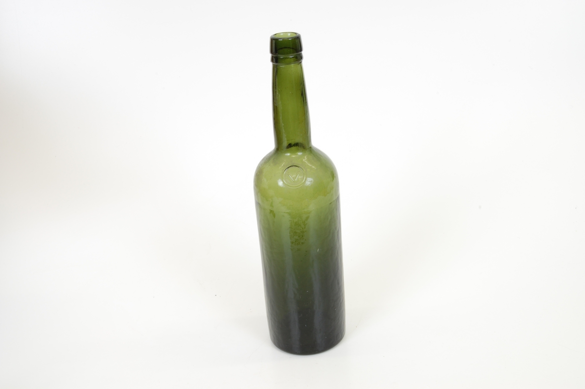 Form: Høy flaske med sirkulær grunnflate, rette vegger og lang hals
