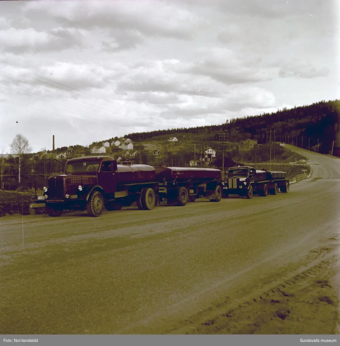 Tankbilar med släp, Timrå Lastbilcentral, Sörberge och Bil & Buss Sundsvall. Bilderna är tagna på Riks 13 (E4)  vid Timrådalen och i bakgrunden syns arbetarbostäderna i Skönvik.