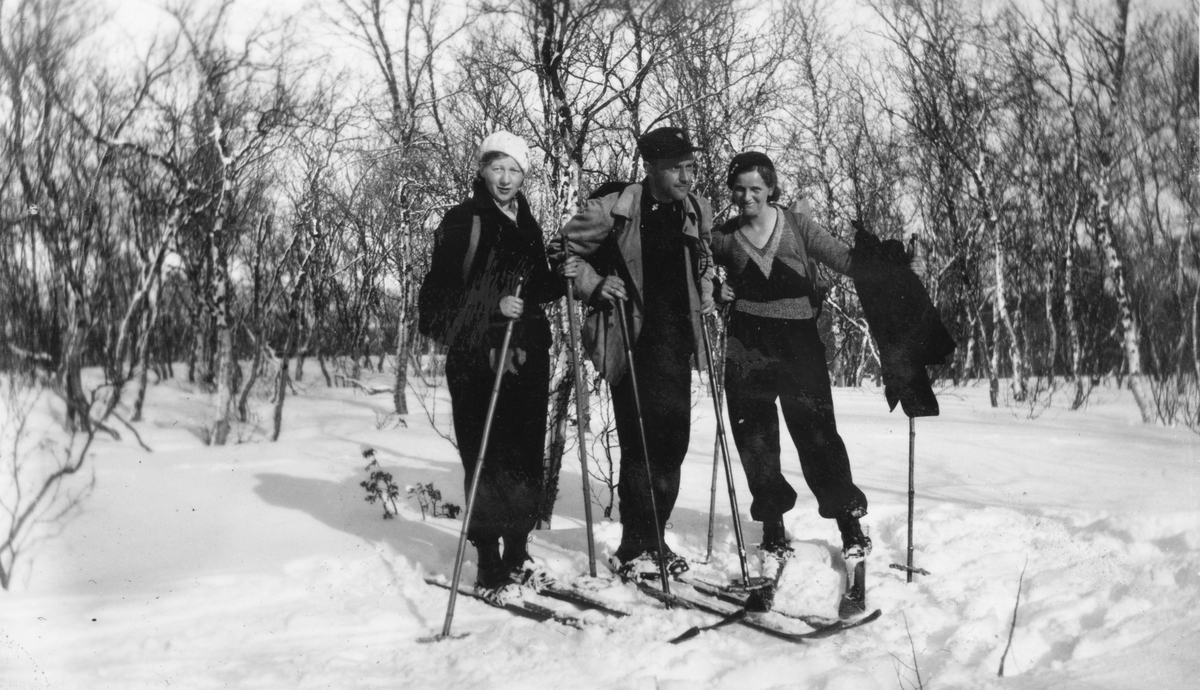 Mann og to kvinner på ski.