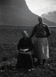 Bildet viser to kvinner, den ene sitter på en stol og den an