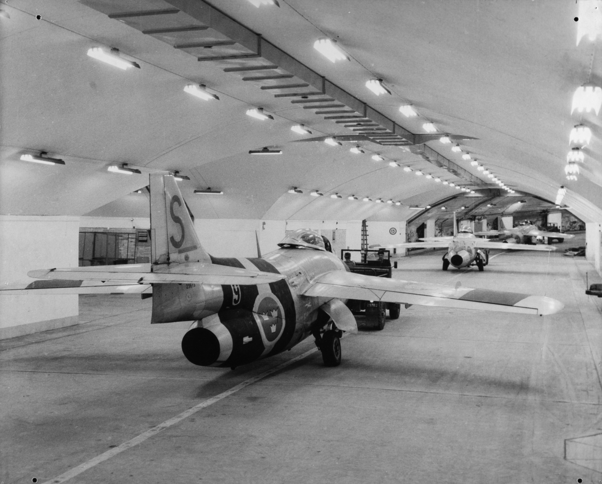 Tre stycken flygplan J 29 Tunnan bogseras i hangar på F 9 Säve.