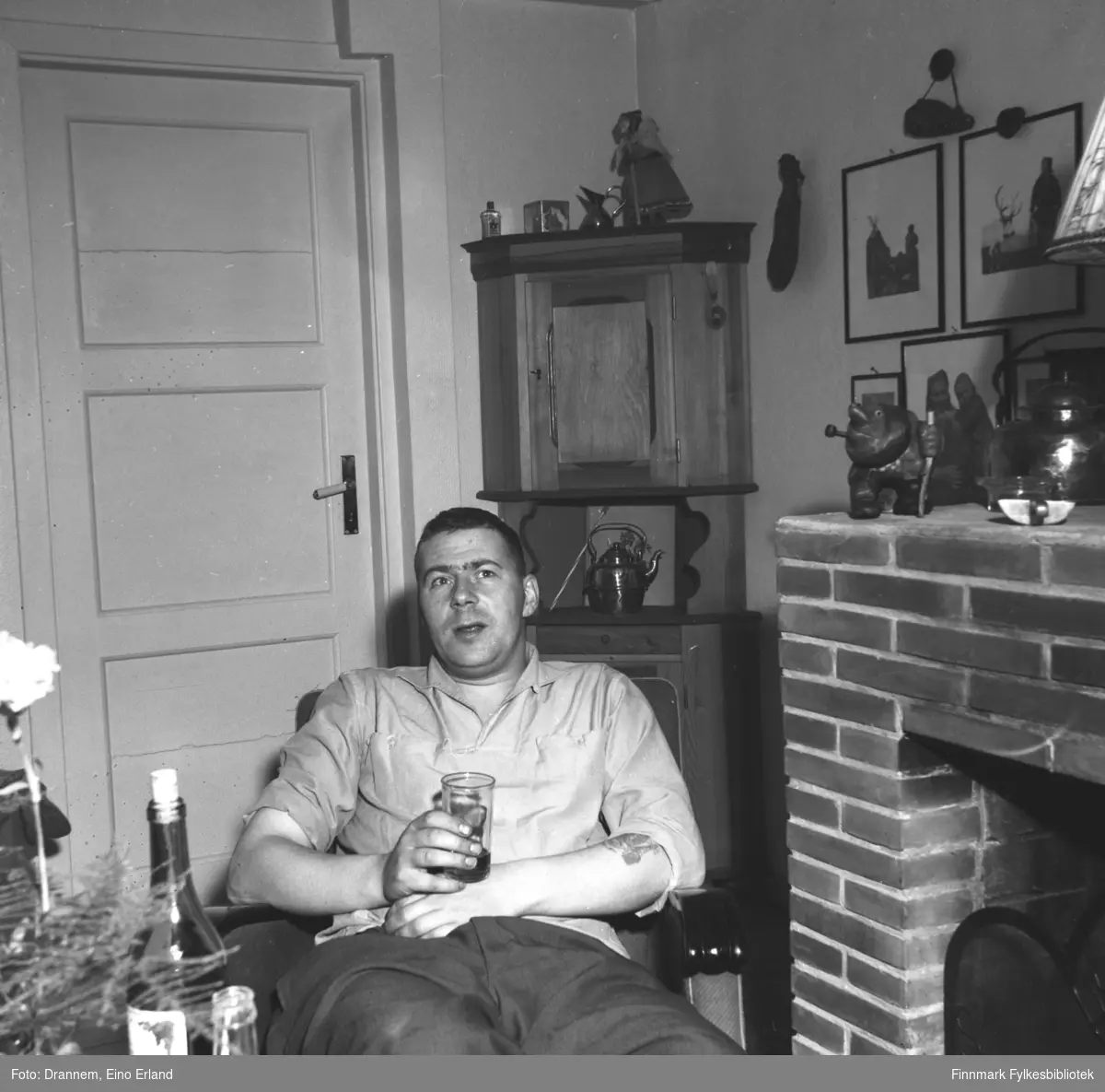En mann sitter i en lenestol glass i hånden
