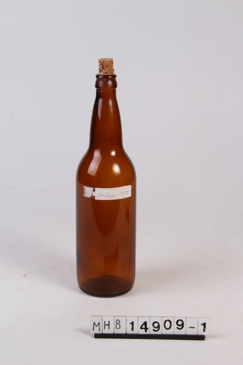 Glassflaske med etikett og trekork. Brukt til oppbevaring av solbærsaft.