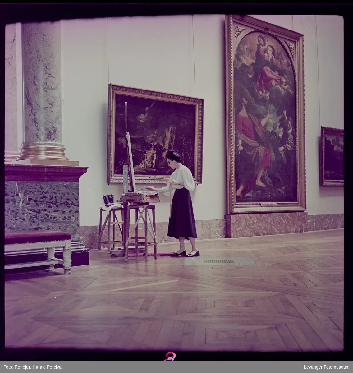 Kvinner maler ett bilde i Louvre (kopierer) med staffeli og målestokk.