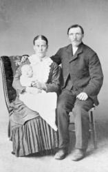 Portrettbilde, mann, kvinne og spebarn på fanget til kvinnen