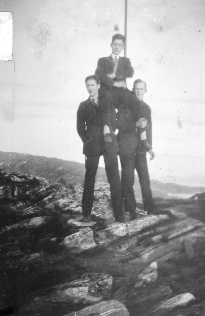 Tre unge menn iført dresser fotografert i terrenget. Personene og stedet er ukjent, men kan være fra Kvalsund kommune.