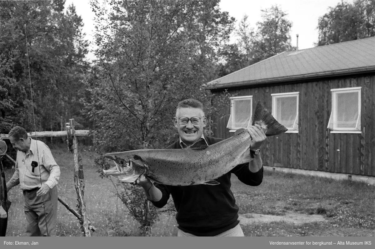 Fangst med personer.

Fotografert mellom 1979 og 1980.

Fotoserie: Laksefiske i Altaelva i perioden 1970-1988 (av Jan Ekman).
