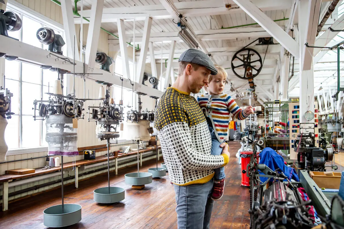 mann og barn i fabrikklokale med maskiner