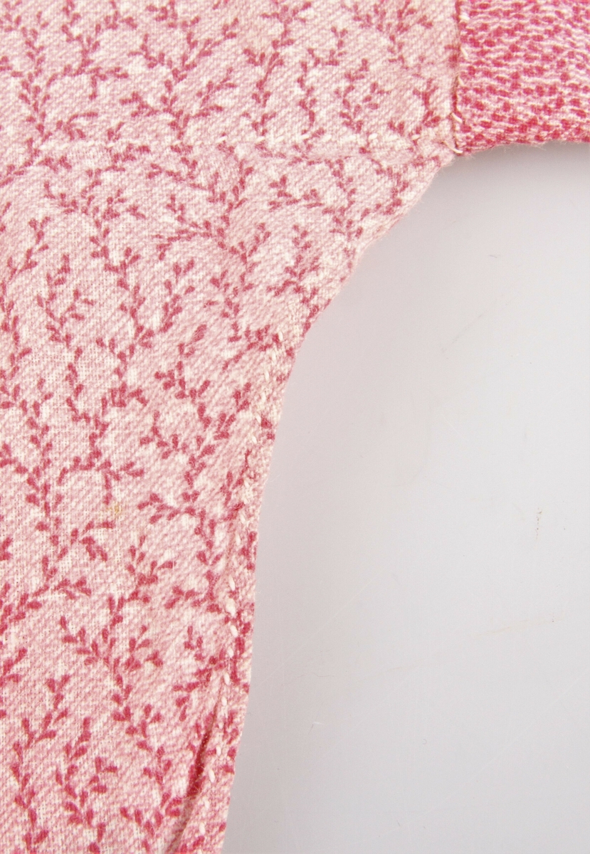 Jakka er sydd av fem ulike rosa bomullstoffer - kattun. Ermene og øverste del er fóret med lin. Den har primærsnitt med åpning foran og i sidene helt opp til armhulen. I halsen er det to sett med knytebånd og ett nederst på ermene. Hele jakka er sydd for hånd med hvit lintråd. 