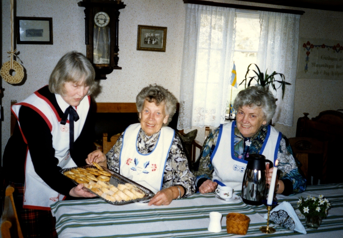 Kaffesöndag i Hembygdsgården Långåker 1:3, 1980-tal. Från vänster: 1. Emy Johansson, 2. Stina Svensson och 3. Inga-Maj Carlsson. Nr 1 och 3 har Långåkers förkläde på sig.