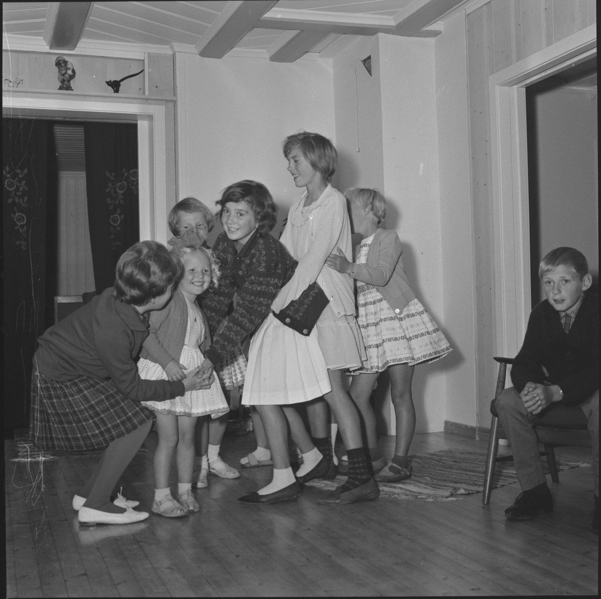 Barn pyntet i selskapsklær leker "bro bro brille". Anne feirer bursdag med nabobarna på besøk. Kaker, brus og leker. Sørum i Gjerdrum 1965