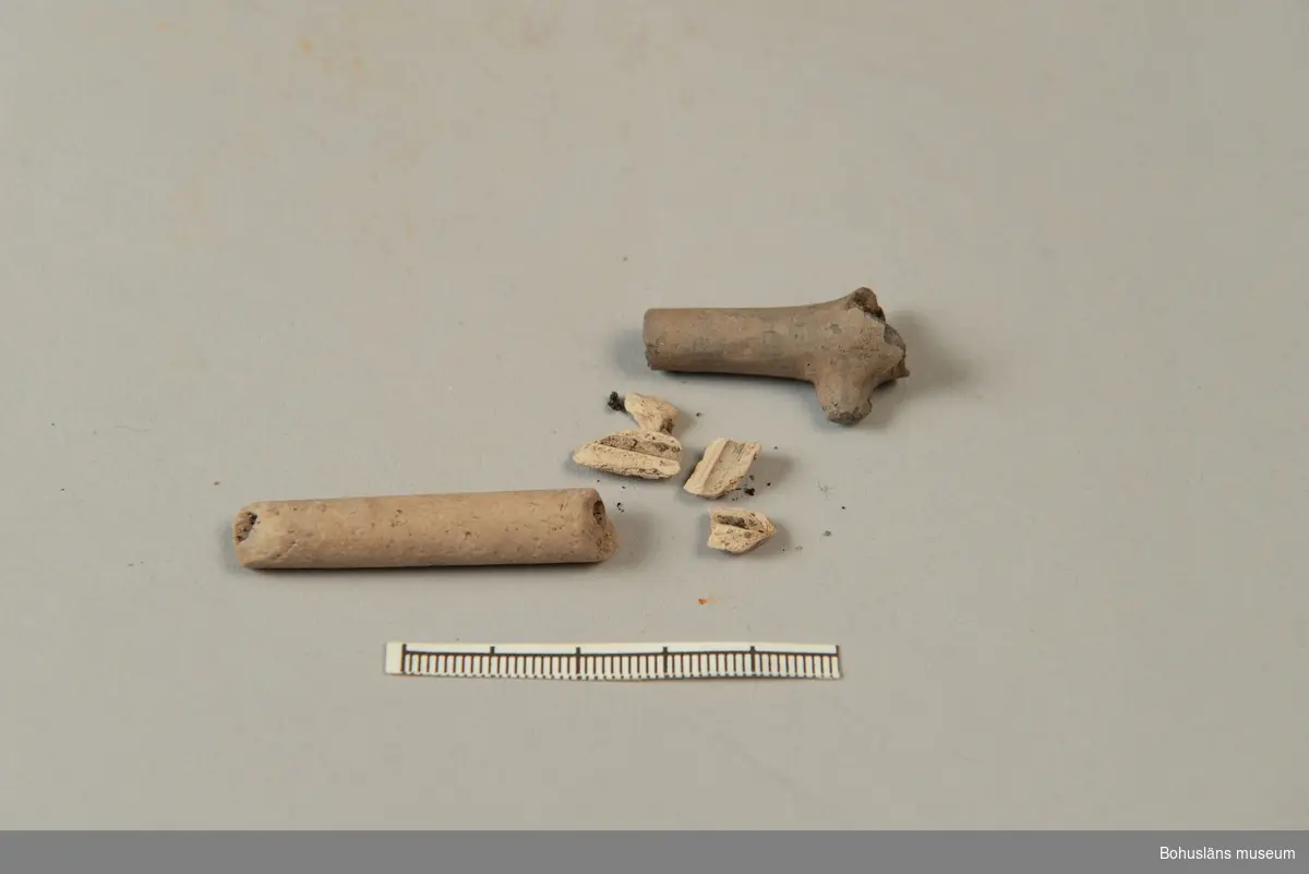 Fragment av kritpipa, delar av skaft, varav ett med klack bevarad (saknar stämpelmärke). Enligt Robert Bergman Carter en mycket enkel typ av pipa, troligen från 1800-1900 talet (2021-09-02).