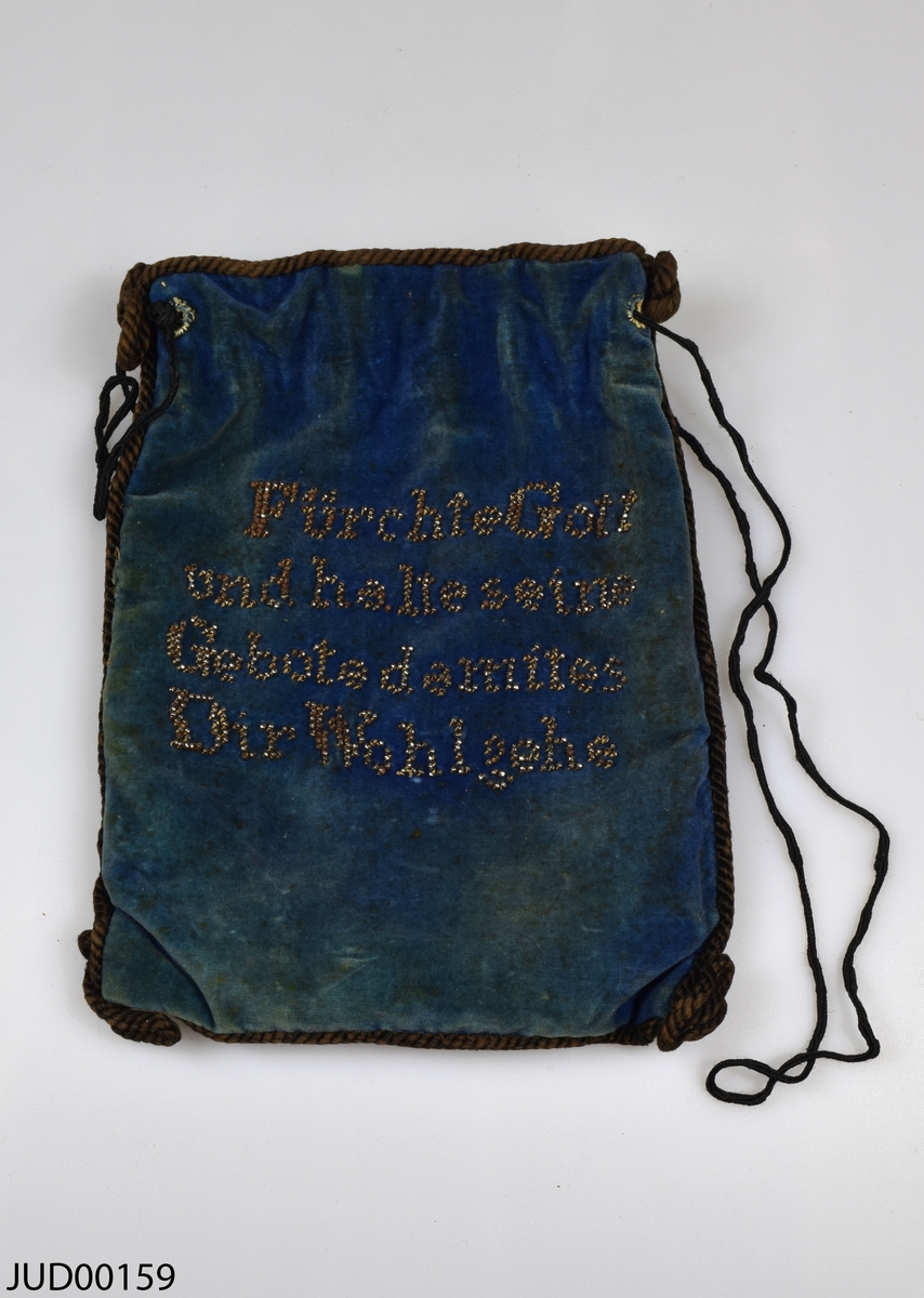 Tefillinpåse tillverkad av blå sammet, med ett par tefillin liggandes i. Fastsydda snören i kanterna och i öppningen. Påsen är dekorerad med ett fastsytt svart sammetsband i form av en davidsstjärna, korsstygn i form av MS. 5643 [1882]. På andra sidan är en tysk text pärlbroderad: "Fürchte Gott und halte seine Gebote demites Dir Wohl gehe".