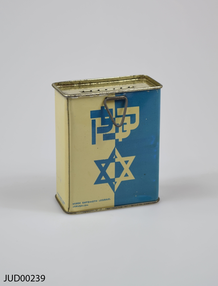 Insamlingsbössa, tillverkad av plåt. Dekorerad med hebreiska bokstäver samt en davidsstjärna.