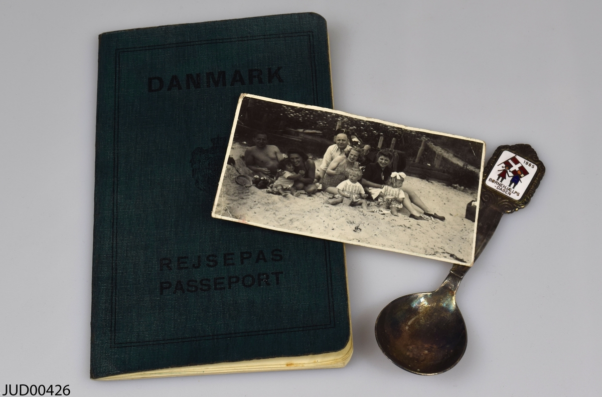 Samling av föremål som tillhört Paula Gringer. 

Ett fotografi föreställande givaren och/eller familjen vid Snekkersten

En silversked. 

Ett reisepass från Danmark.
