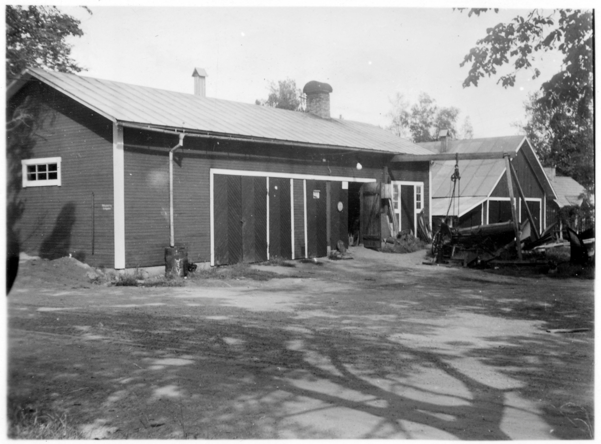 Vägstation W1, Lund. Förråds- och garagebyggnad. Spetsplogar, sidoplogar på garageplan. I bakgrunden en garagebyggnad.