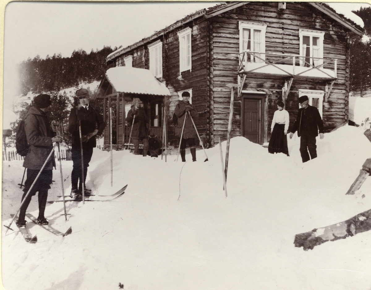 Fire skigåere er klare til å forlate antagelig Tronhus Turiststasjon i Randsverk. Til høyre antagelig vertskapet med Jens Tronhus ytterst. Fotografert mars 1908.