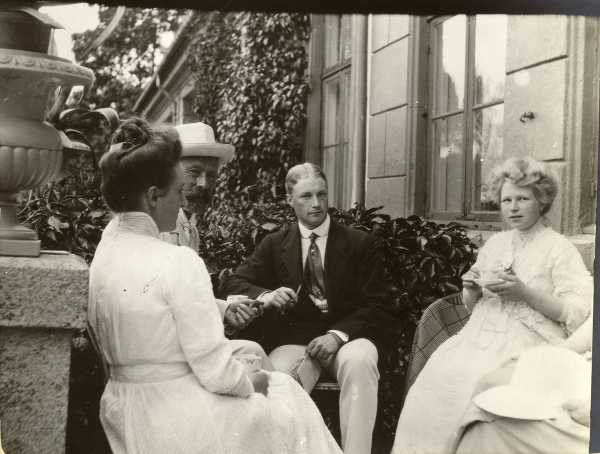 Kaffepause på verandaen til Bogstad gård. Fra venstre Nini Egeberg, Ferdinand Egeberg og hans barn Oscar Egeberg og Ester Egeberg, gift Finne. Fotografert 1909.