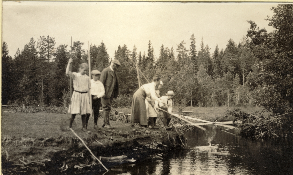 Familien Egeberg og to ukjente gutter på krepsefiske ved Skinnarbølåa ved Kongsvinger. Fotografert 1917.