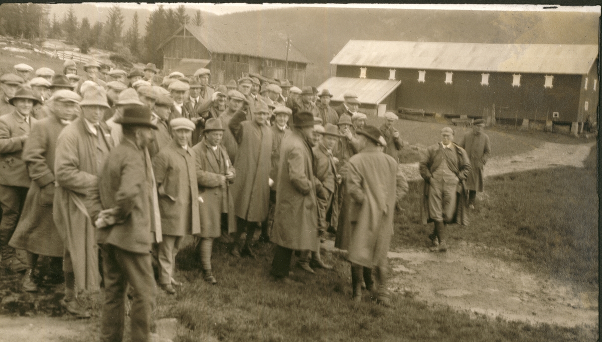 Medlemmer av Forstmannsforeningen på utflukt til Fritzøe i Larvik. Her kanskje ved Fritzøehus. I bakgrunnen to store driftsbygninger. Fotografert 1924.