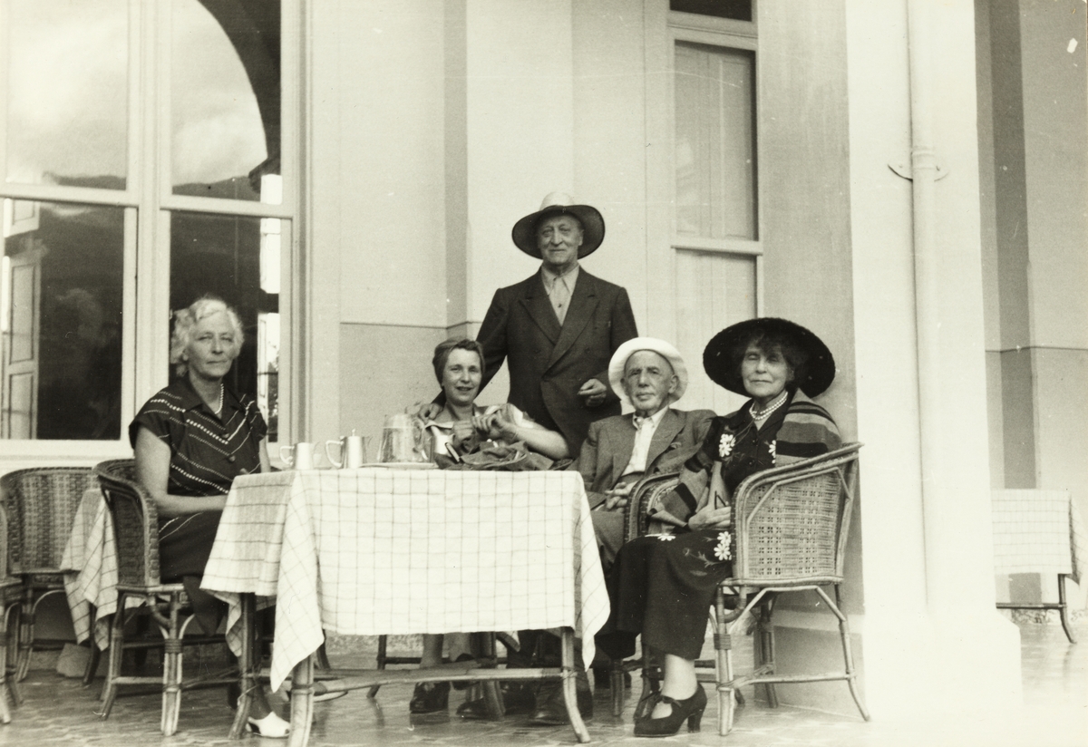 Norske turister ved bord på verandaen til Gran Hotel Taoro, Puerto de la Cruz, Tenerife. Fra venstre fru Gresvig, Evelyn Løvenskiold, hr. Heitmann-Jacobsen, hr. Gresvig og fru Heitmann-Jacobsen. Fotografert 1953. 