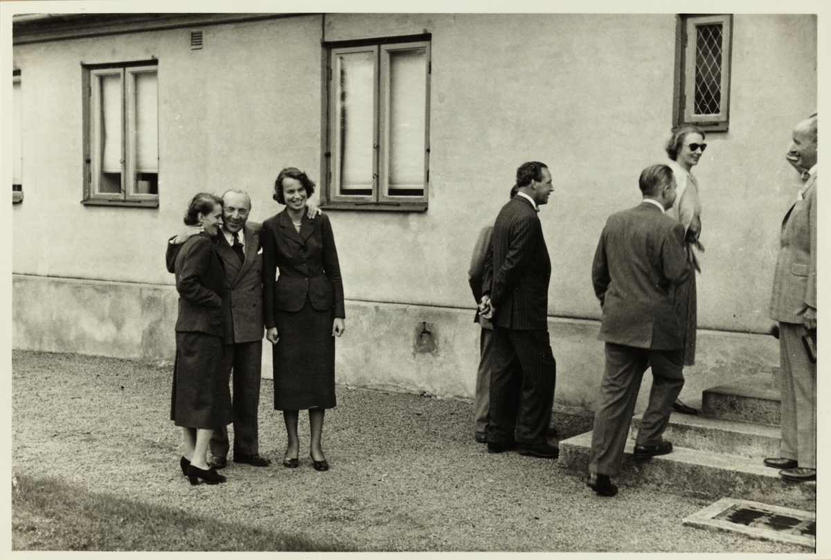 En gruppe kvinner og menn på vei inn i et bolighus. Antagelig fotografert i forbindelse med et besøk  i Sverige i 1953.