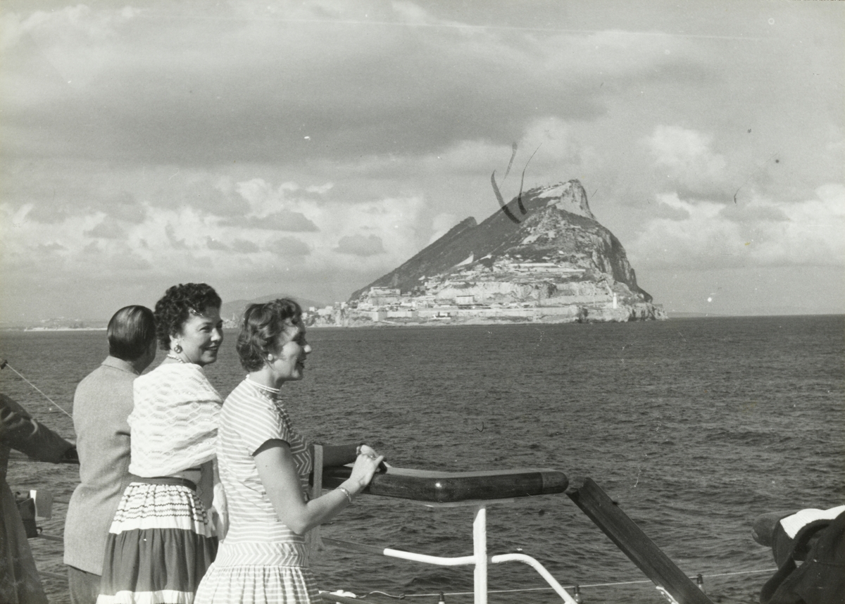 Passasjerer ved relingen på M/S Oslofjord. I bakgrunnen Gibraltar. I bakgrunnen "Rock of Gibraltar".