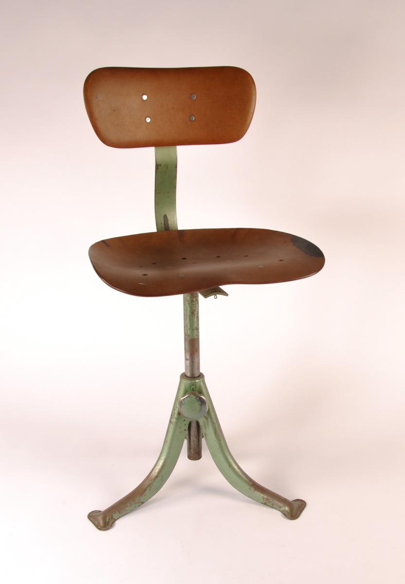Arbeidsstol av grønnmalt metall med sitteplate og ryggstøtte av formpresset tre.
