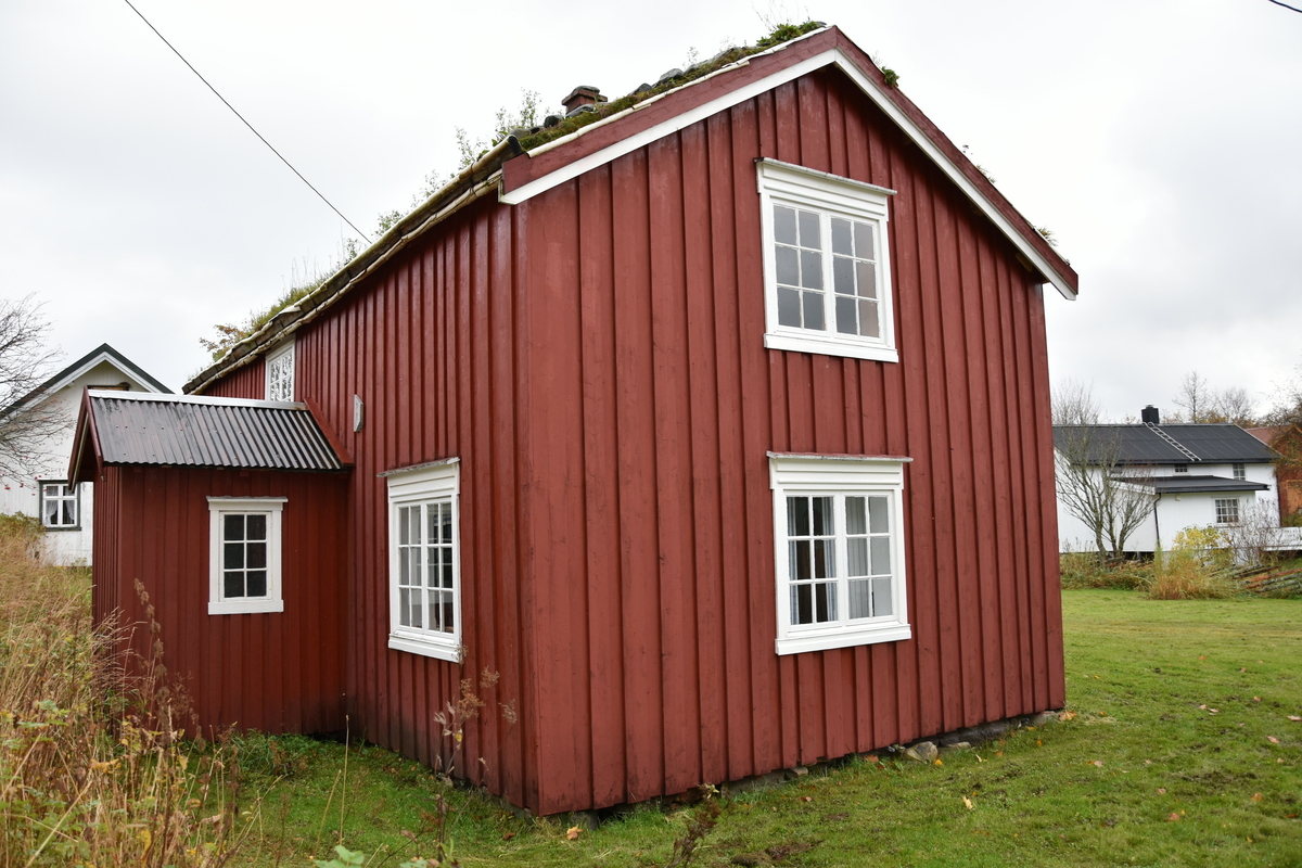 Laftet bygning med tømmermannskledning. Rødmalt med hvit kontrastfarge på omramminger.