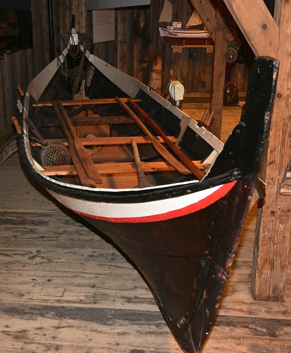 Båten er en klinkbygd treroing med 5 bordganger, som har 3 årepar.