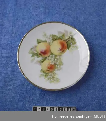 Fruktmotiver med gullstaffasje langs randen.