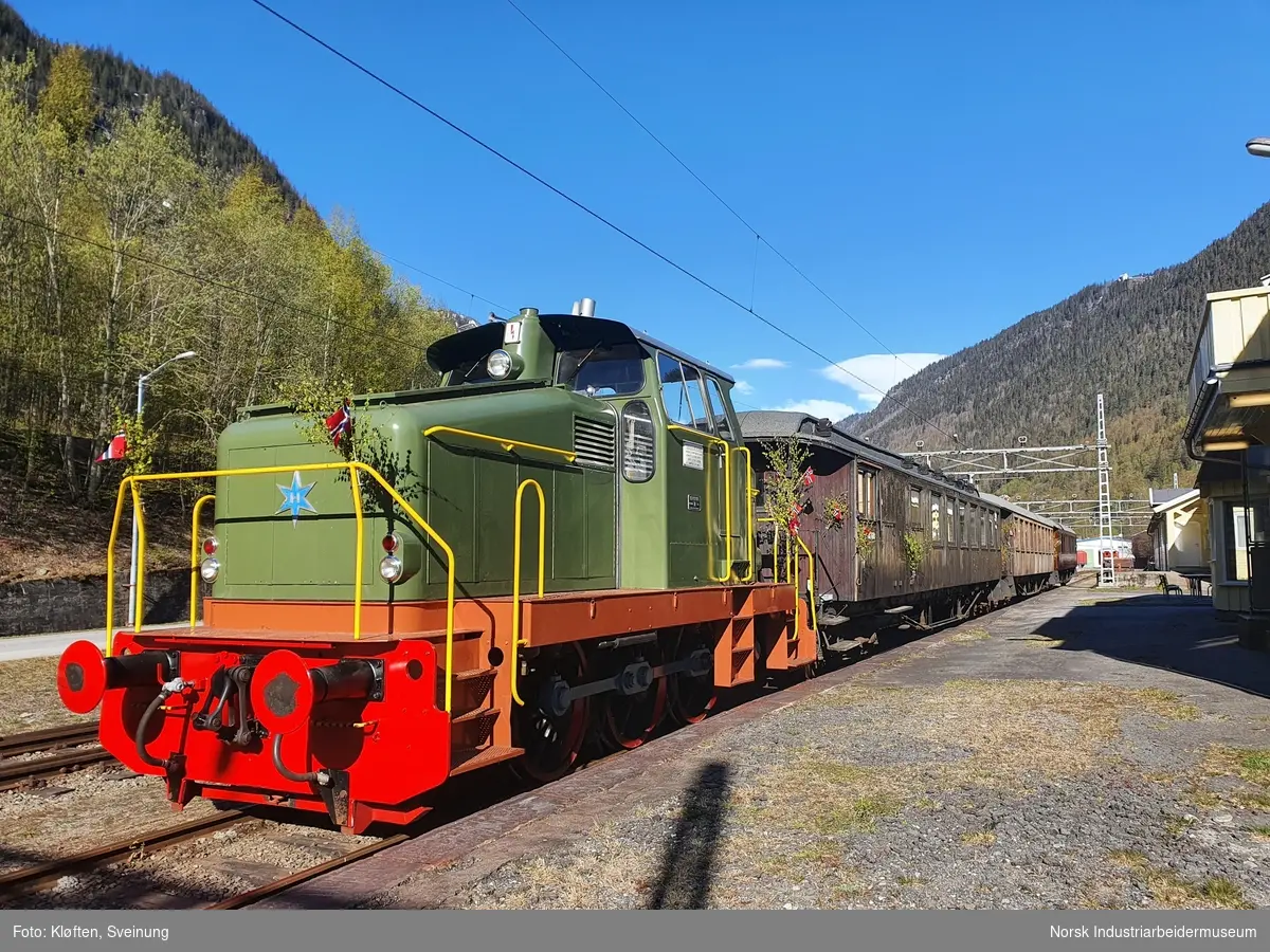 Grønt lokomotiv. Før ny lakkering i 2019 var lokomotivet orange med blå striper tvers rundt.