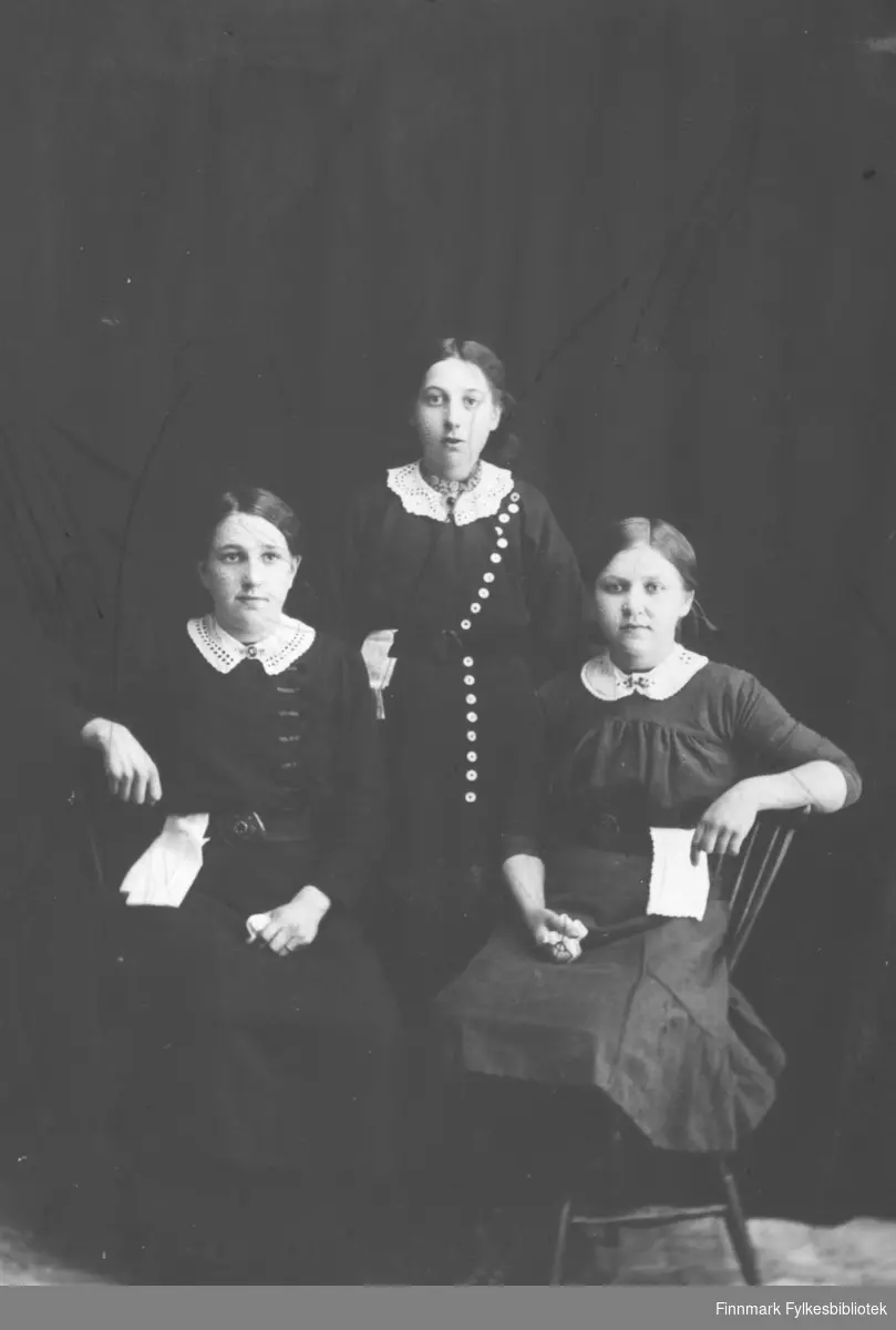 Fotoatelierportrett av tre unge og finkledde jenter. Kanskje bildet er tatt ang. konfirmasjonen?