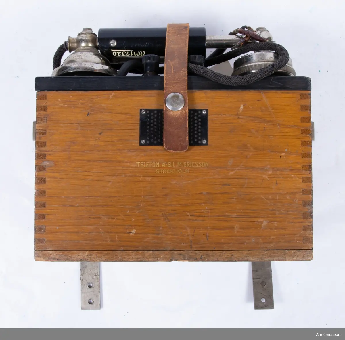 Väggtelefonapparat, 1930-tal.
Uppgifter på typ och modellår saknas. Telefonapparaten har tillhört Radiotjänsts tekniska avdelning. Märkt: Telefon A-B.L.M. Ericsson Stockholm. Induktorvev och batteri saknas.