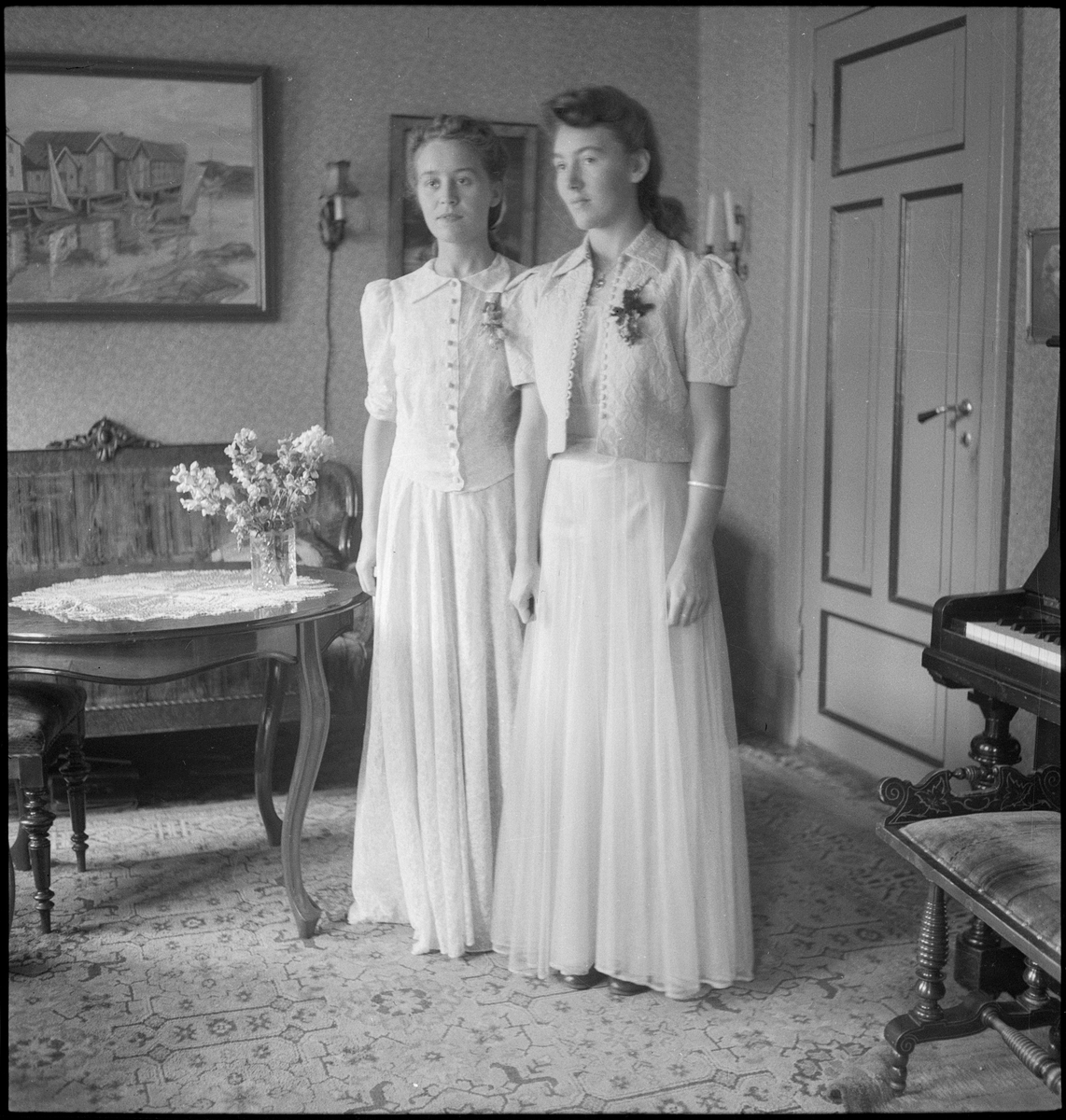 Portrett av to unge kvinner i kjole, Edith og Maria. På bilde 5, 6 og 7 er det bare den ene kvinnen i penkjole og revestola.